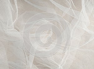 White mosquito net fabric texture with folds. Wavy chiffon background. Full frame of crumpled white cloth material texture.