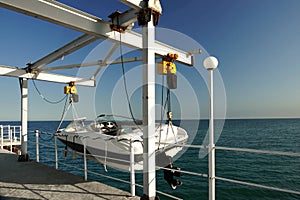 White Motor Boat Hanging On The Pier Davit photo