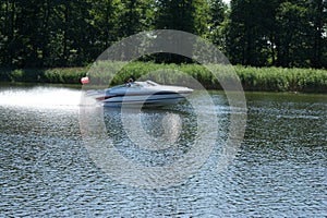 The white motorboat rushes quickly on the lake