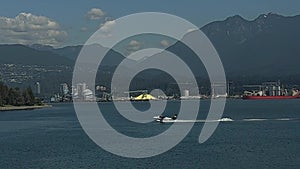 A white motorboat sails from right to left in slow-motion video across the pacific ocean off the coast of Vancouver