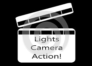 A white movie clipper board with the words lights camera action against a black backdrop