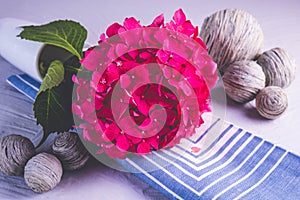 White mug with a branch of pink hydrangea and decorative balls