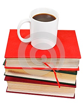 White mug of coffee on stack of books