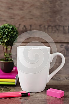 White mug mockup. Blank mug. Coffee mug mockup with bright neon colors pencils and notebooks. Potted plant bonsai behind
