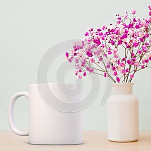 White Mug Mockup, next to a single flower in a glass vase.