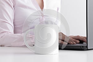 White mug mockup with woman working on a computer