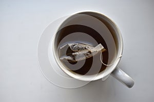 White mug with tea on a white background