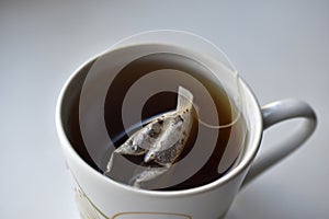 White mug with tea on a white background