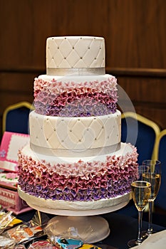 White multi level wedding cake with pink flower decorations