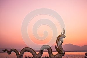 White Naga statue at Kwan Phayao with evening sun