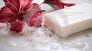 White natural soap with red flower on a milky white wet surface, close-up, selective focus.