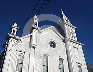 White New England church with three steeples and dark blue sky