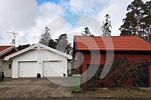 White new garage for two cars and wooden barn on private house yard