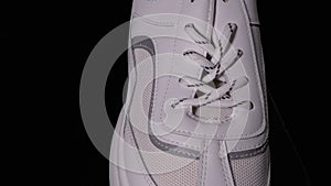 White New Sneaker Rotates on a Black Background. Sport Female Shoes