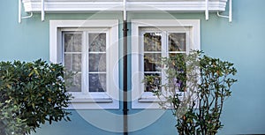 White new windows on the blue house wall.