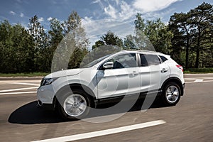 White nissan qashqai crossover side view in motion