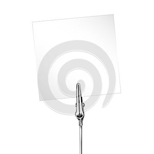 White note on a metal memo holder clip. Note on wire silver clamp with place for you text over white background. Office supplies.