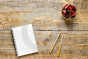 White notebook with flower sachets on wooden table