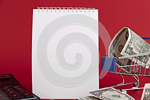 White notepad with calculator and stylish pen on a red background. Copy space