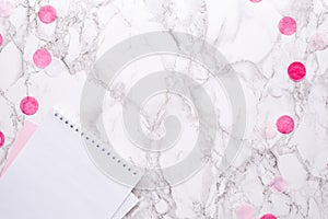 White notepad with pink decorations on a marble background in the office