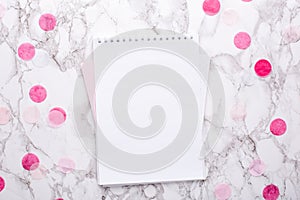 White notepad with pink decorations on a marble background in the office