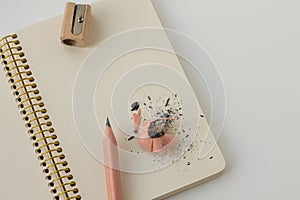 White notepad with spiral and stick pencil, with wooden sharpener