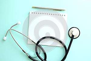 White notepad and a stethoscope on a blue background.