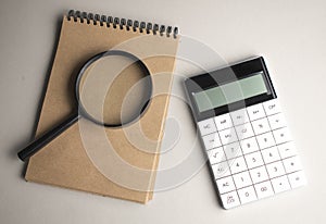 White notepad with stylish pen, magnifying glass and calculator on red, blue background. Copy space