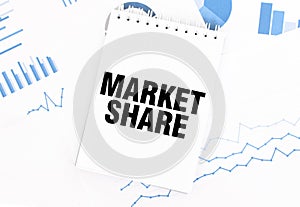 White notepad with text MARKET SHARE on the financial documentation. Finance and business concept