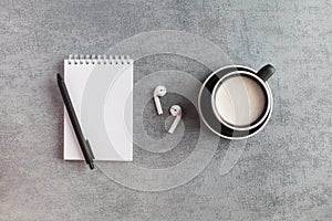 White Notepad, wireless headphones, coffee mug. The concept of online training, work from home, home office. Copy space
