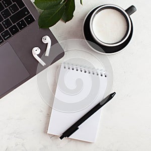 White Notepad, wireless headphones, coffee mug. The concept of online training, work from home, home office. Copy space