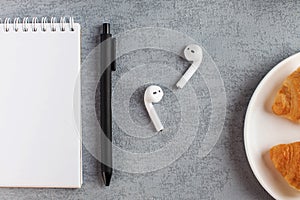 White Notepad, wireless headphones. The concept of online training, work from home, home office. Copy space