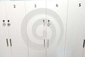 White numbered lockers in the corridor of the waiting room of a medical clinic or spa salon in minimalist stylish design