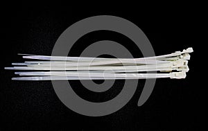 White nylon cable tie isolated on a black background