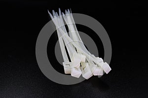 White nylon cable tie isolated on a black background