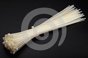 White nylon cable tie or zip tie on black background