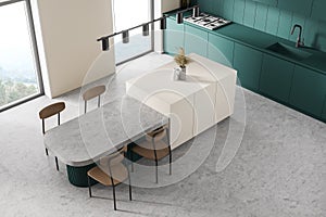 White and ocean green modern kitchen interior near window. Dining area with table. Concrete floor. Tall window. Top view