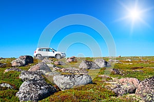 White off-road vehicle on peak of green hill