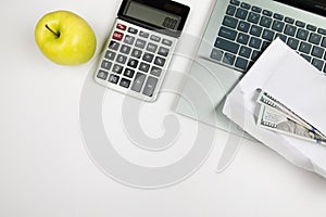 White office desk with a laptop and a lot of things on it