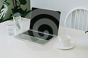 White office desk with note pad and laptop