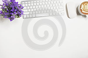 White office desk table with computer keyboard, mouse, and cup of coffee. Top view with copy space, flat lay