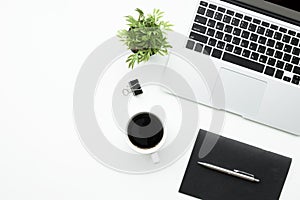 White office desk table with laptop computer, cup of coffee and office supplier. Top view with copy space, flat lay