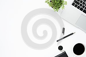 White office desk table with laptop, cup of coffee and supplies. Top view with copy space, flat lay