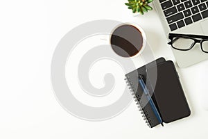 White office desk table with laptop, and smartphone and pen with coffee cup, copy space