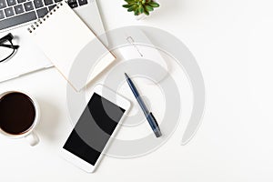 White office desk table with laptop, and smartphone and pen with coffee cup, copy space