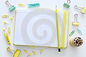 White office desk table with open notebook with empty pages and other office supplies. Top view