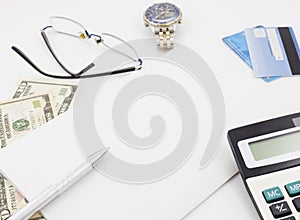 White office desk table with pen calculator glasses and banknote