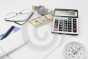 White office desk table with pen calculator glasses and banknote