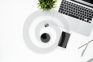 White office desk table with smartphone, laptop computer and supplies. Top view with copy space, flat lay