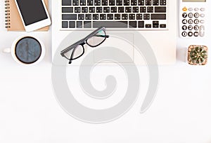 White office desk table, workspace office with laptop, smartphone black screen, coffee cup,pen,calculator, glasses, Top view with